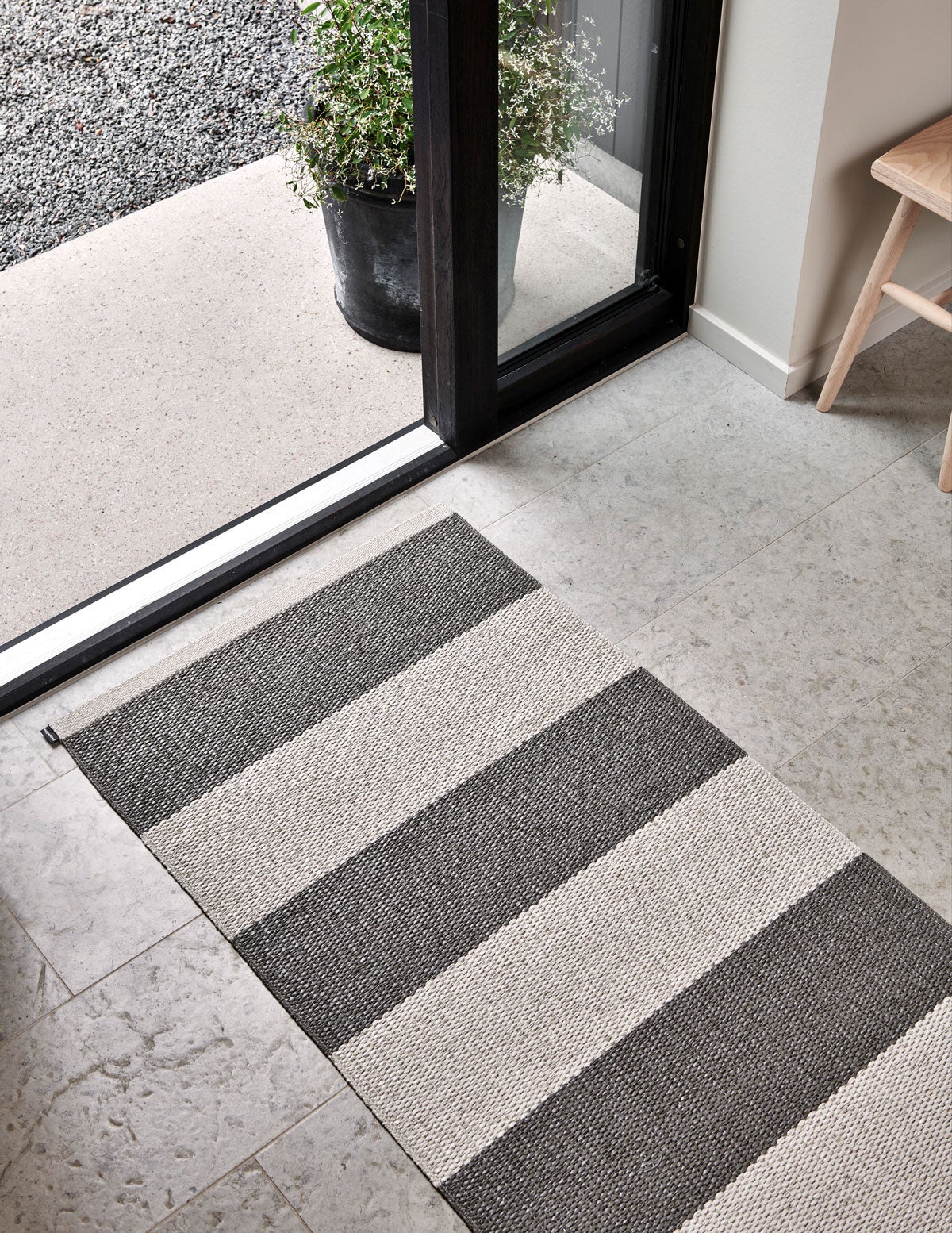 Bob Gångmatta i färgen Charcoal / Linen framför öppen dörr