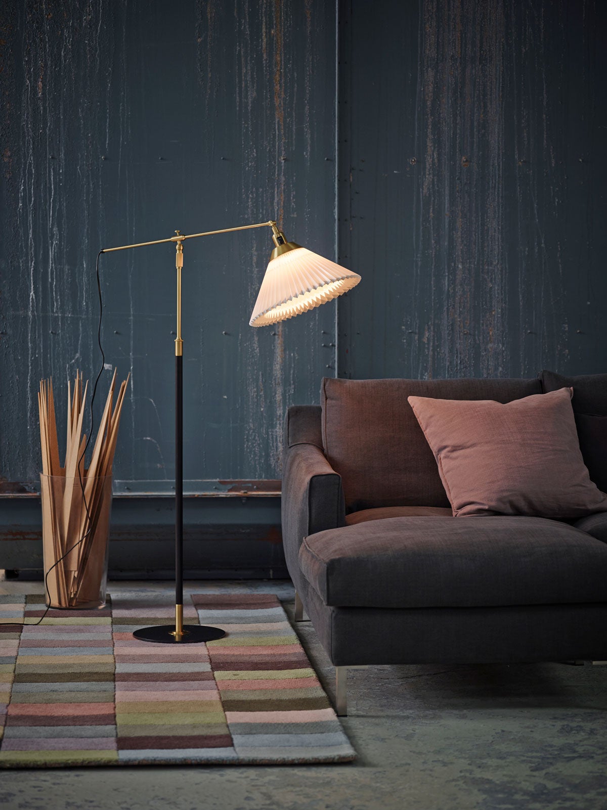 En tänd Le Klint 349 Golvlampa bredvid soffgrupp