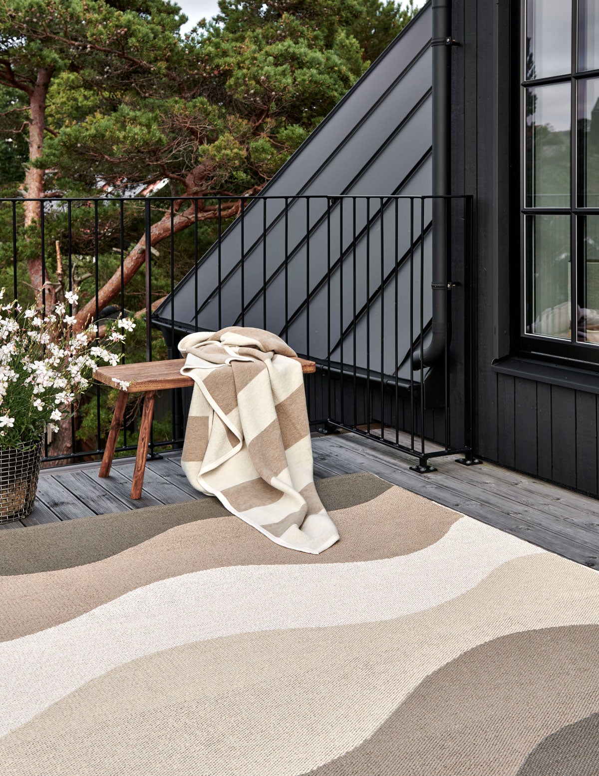 Bob Pläd i färgen Mud / Vanilla på bänk utomhus