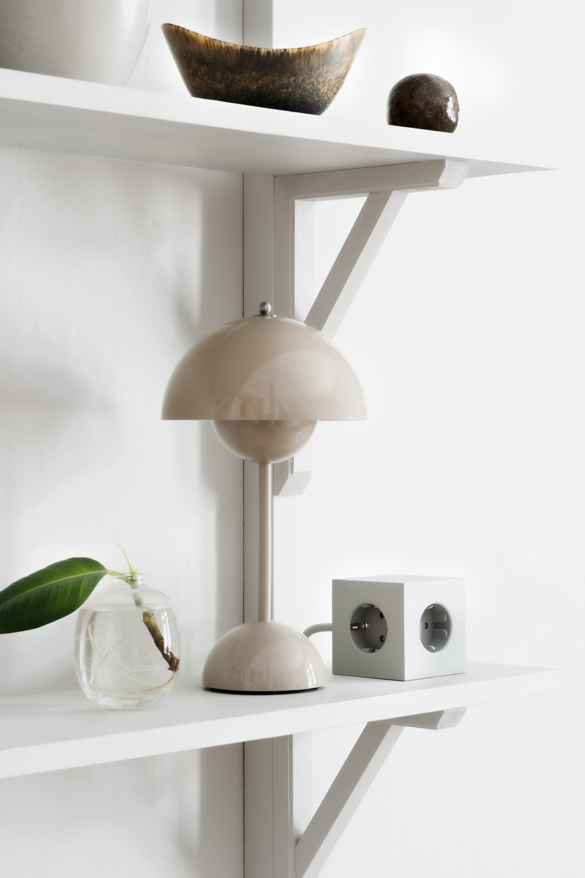 Square-1-Grenuttag-Gra-Miljo.jpg Square 1 Grenuttag Grå på en vägghängd hylla bredvid en beige bordslampa