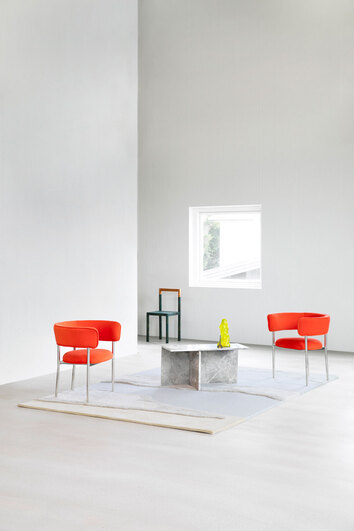 Cloud9 Matta Morning i högt rum med soffbord i sten, två röda fåtöljer och en svart stol vid ett fönster