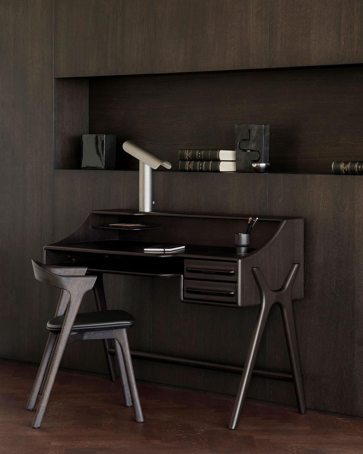 Flow Skrivbord i mahogny i färgen Rose Brown i ett rum klätt i mörkt trä