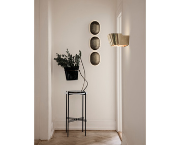 9464 Vägglampa ovanför sidobord med kruka