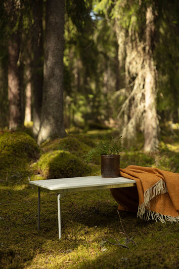 Bänk 8 i vitlackad ek från Grythyttan i solig skog med orange pläd