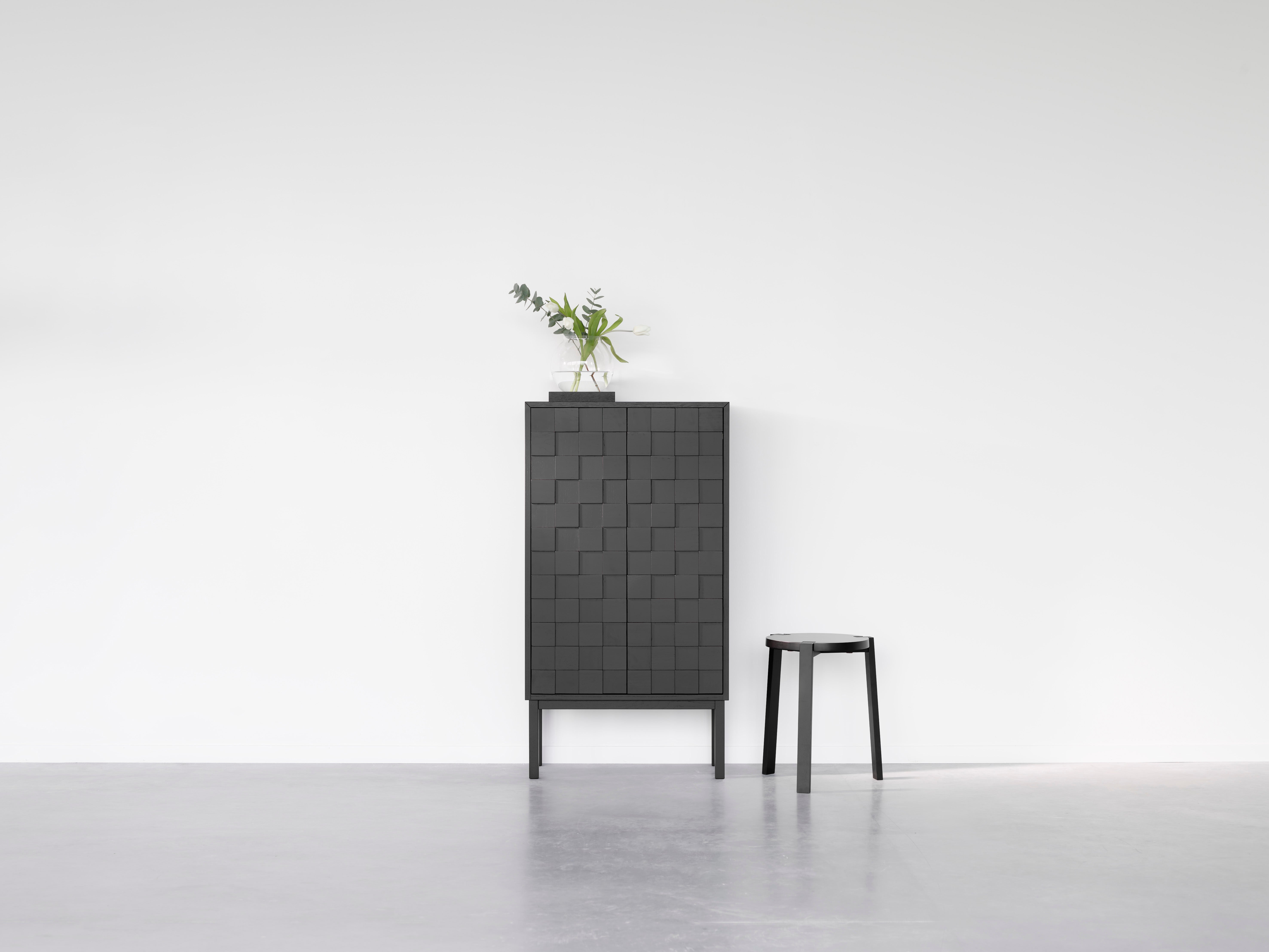 Collect 2016 Skåp Högt Svartmålad Ek med vacker vas bredvid en svart pall