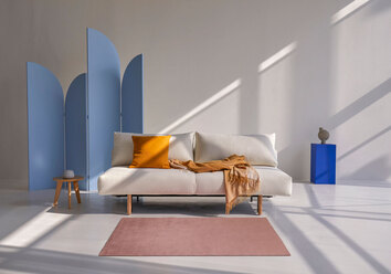 Frode Bäddsoffa klädd i tyget 531 Bouclé Off White i färgglad studiomiljö