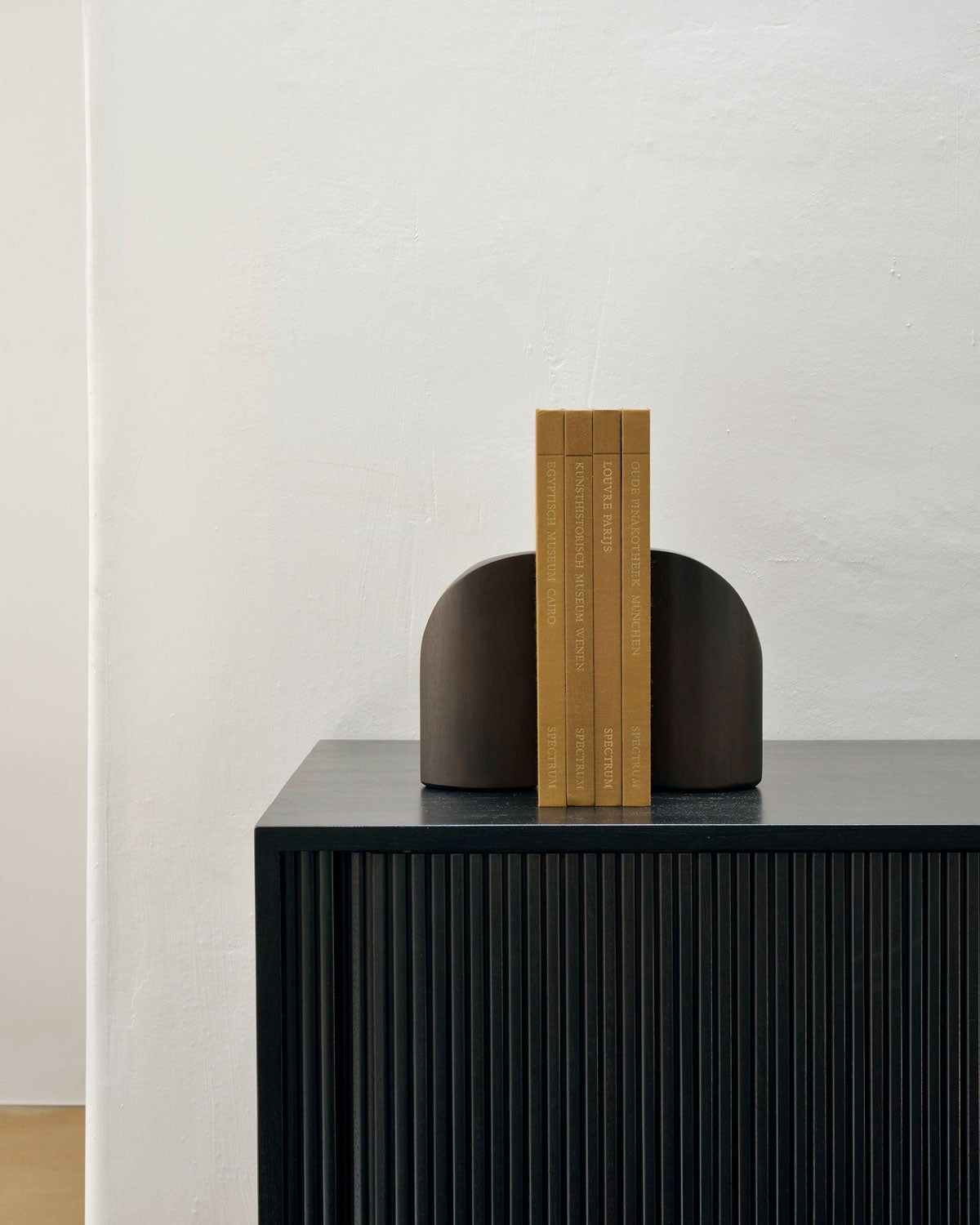 PI Bokstöd Brunbetsad Mahogny som håller upp tre böcker