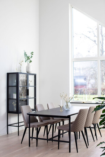 Miljöbild på stolen Flair i beige tyg. Här visat med matbordet Cane.