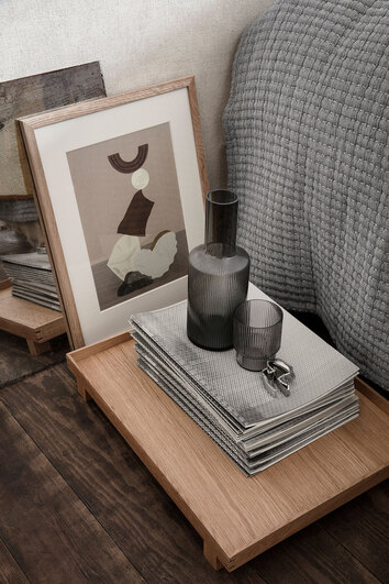 Ripple Karaff i färgen Smoked Grey på sängbord bredvid en säng