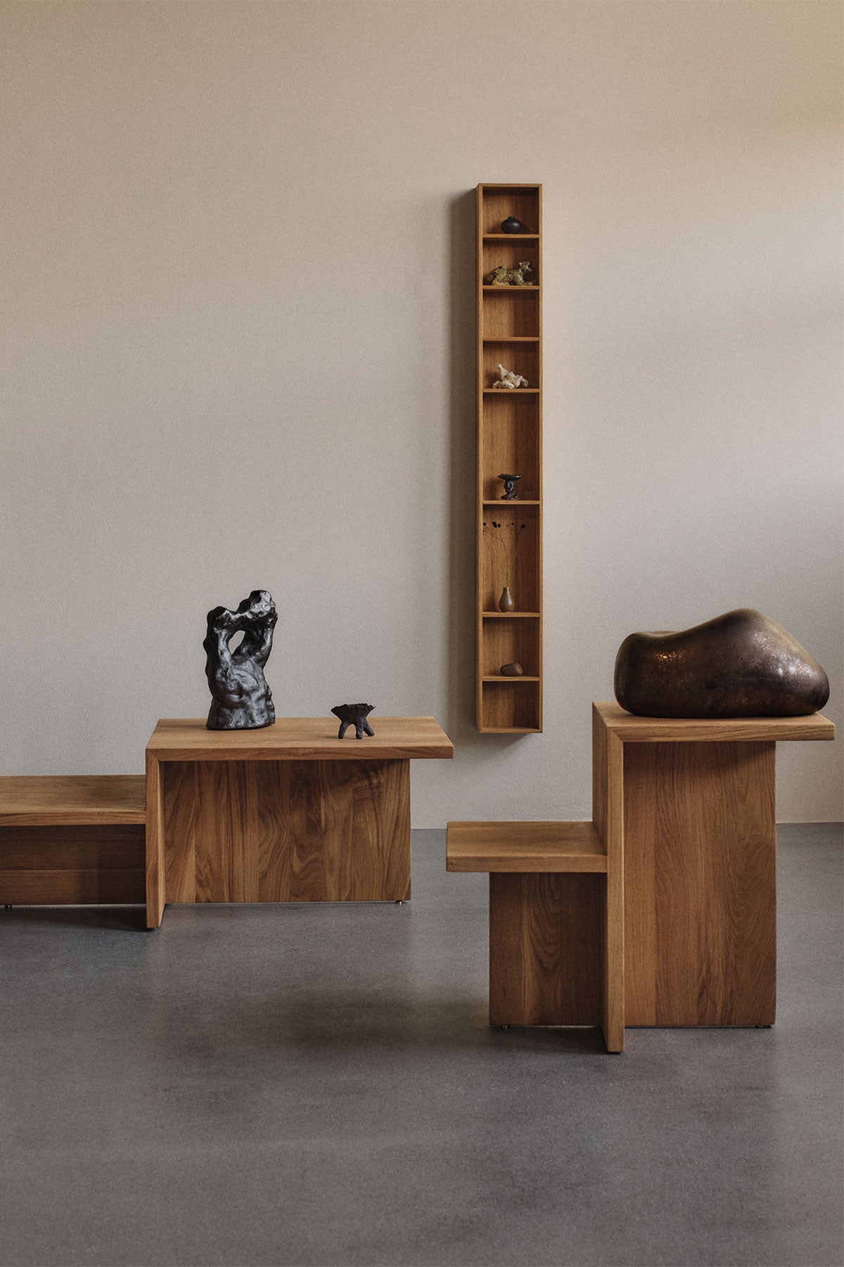Distinct sidobord i ek tillsammans med Distinct soffbord i ek i rum med gråa väggar. 