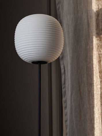 Lantern Golvlampa vid beige gardin i linne