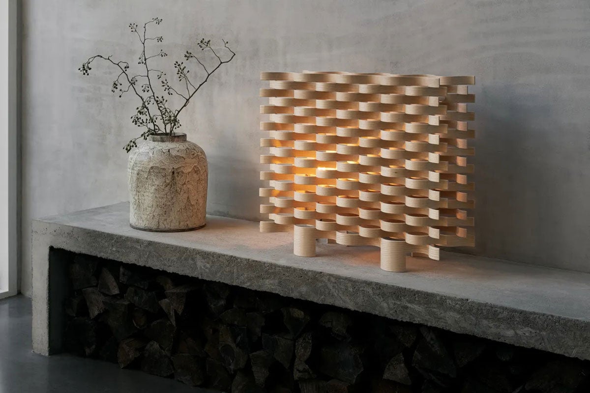 Pile Lampa på en bänk i betong bredvid en kruka i sten