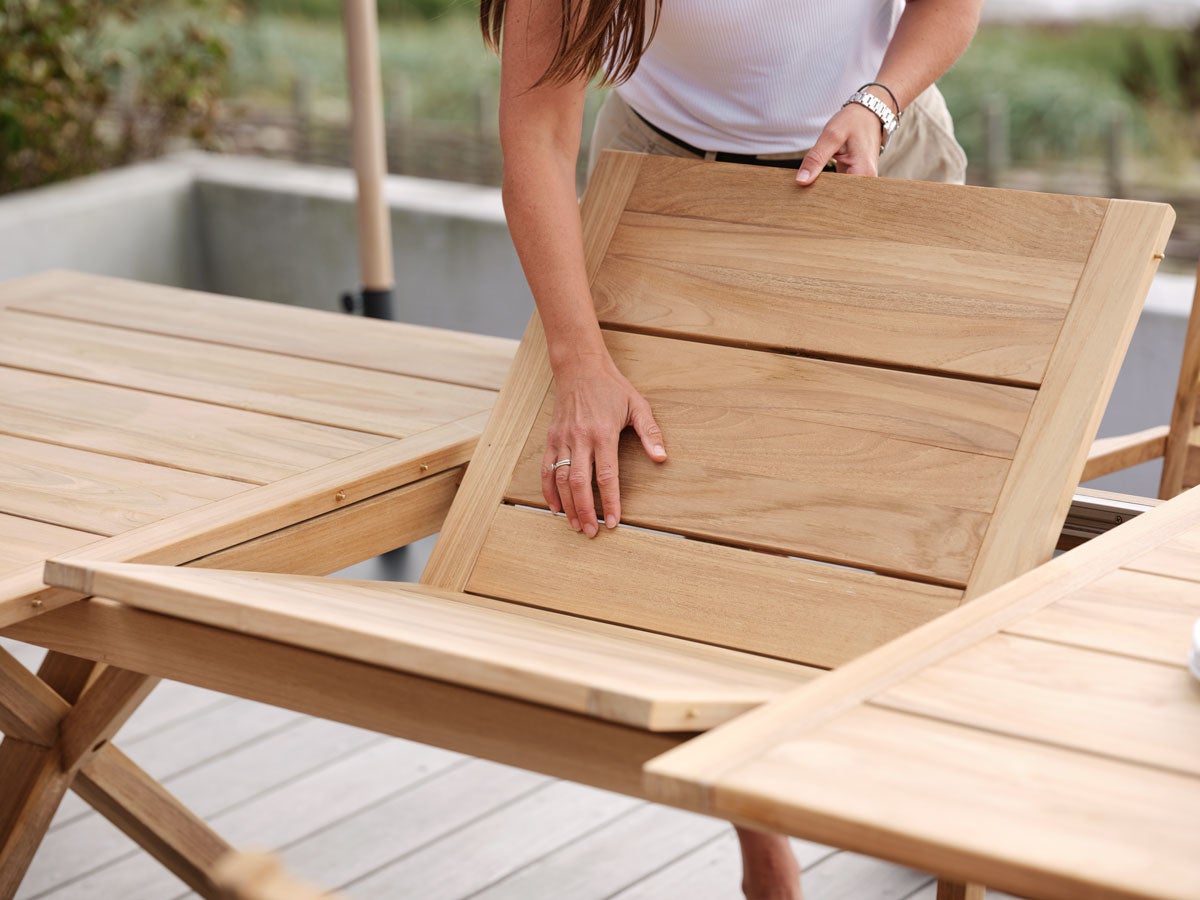 Kvinna som lägger i en iläggsskiva i Brutus Matbord