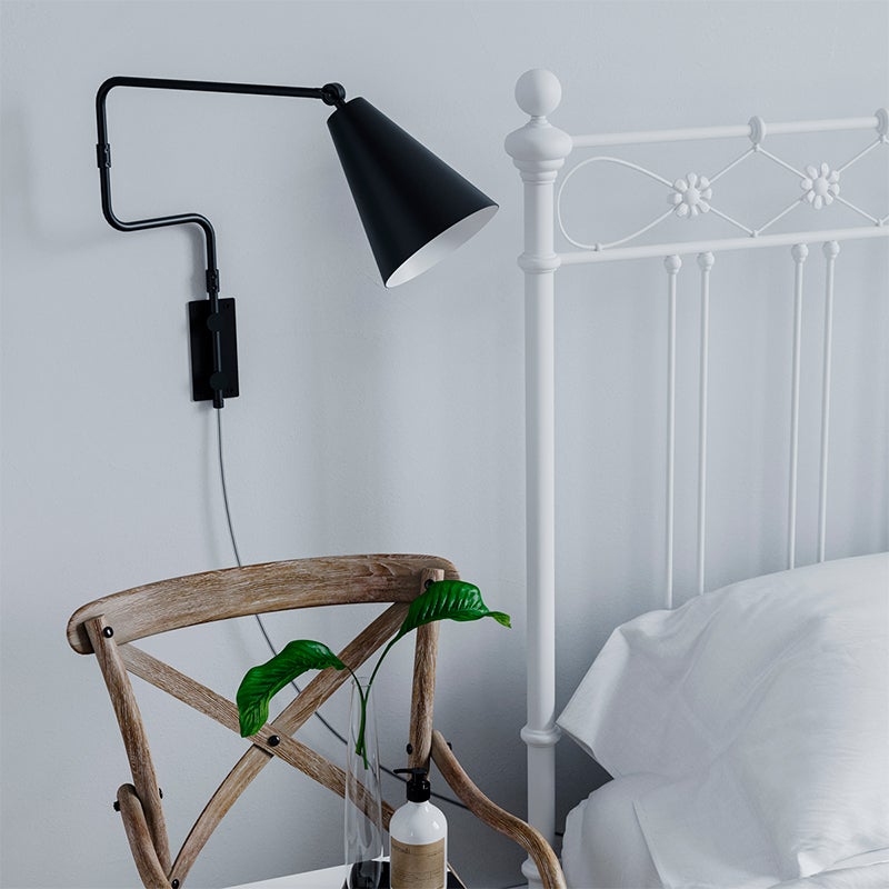 Yukon Vägglampa Svart på vägg bredvid säng med vit sängram