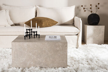 York Soffbord Beige på en fluffig matta med en beige soffa i bakgrunden
