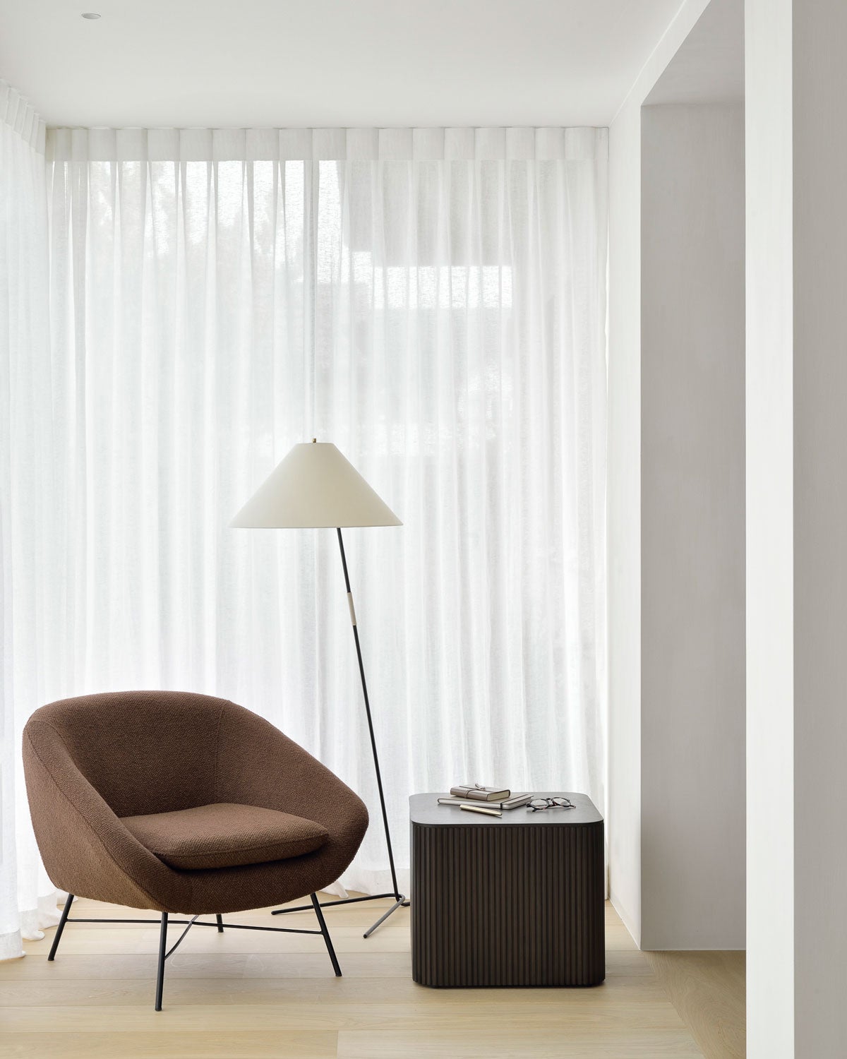 Barrow Fåtölj i Copper vid fönster med skira gardiner bredvid en golvlampa och ett kvadratiskt sidobord