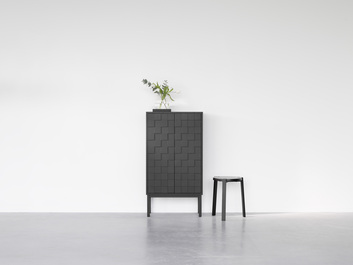 Collect 2016 Skåp Högt Svartmålad Ek med vacker vas bredvid en svart pall