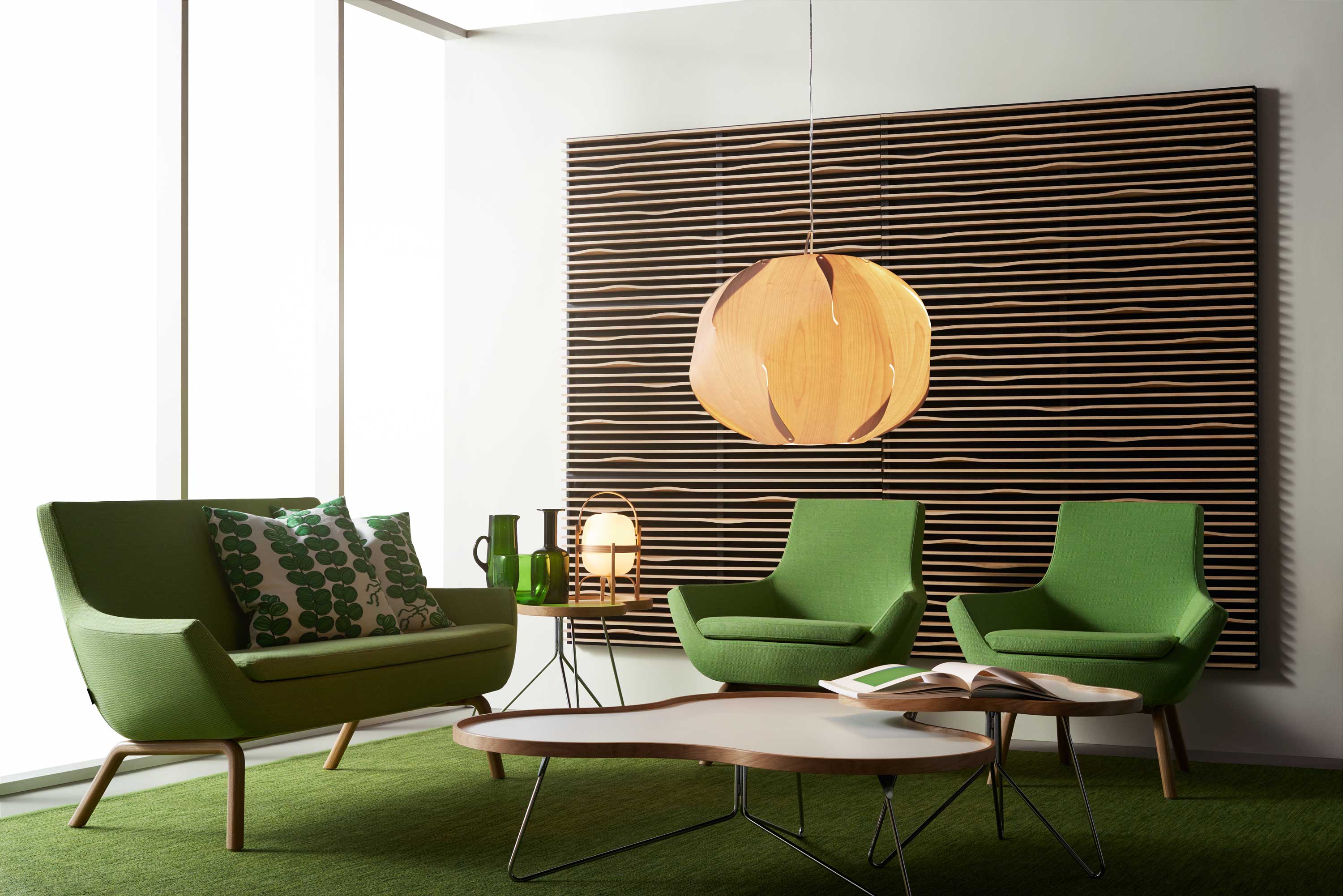 Flower Soffbord i kontorsmiljö med grön soffa, gröna fåtöljer och gröna inredningsdetaljer