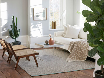 Effi Matta Haze under soffgrupp med Honey Pläd Sand utlagd på soffan