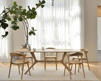 X Matbord med Bok Stol i matplats med skira gardiner och stor fikus