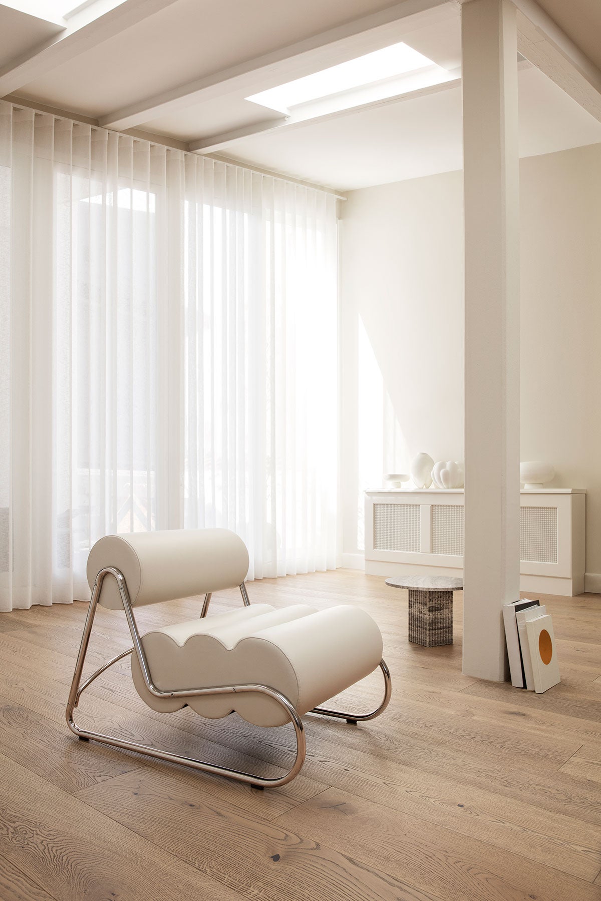 Fave Fåtölj med ben i krom klädd i ljust läder i öppet vardagsrum