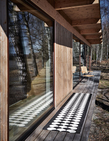 Poppy Gångmatta Black utomhus utanför ett hus i trä