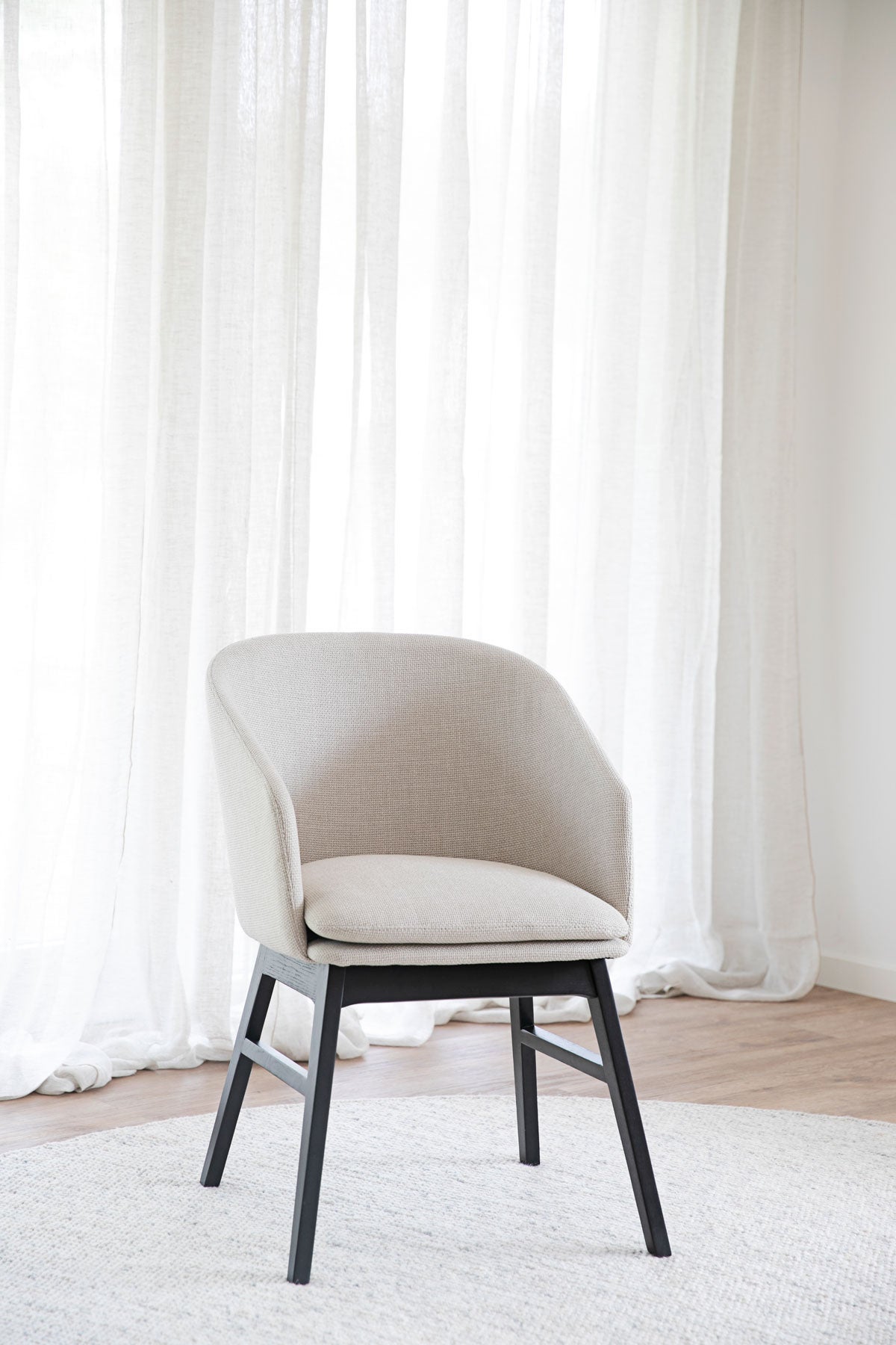 Windham Karmstol Beige / Svart Ek på ullmatta framför fönster med skira gardiner