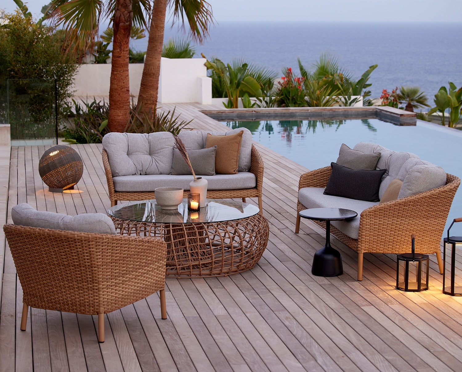 Ocean Soffa och Fåtölj från Cane-Line intill poolkant i skymningen