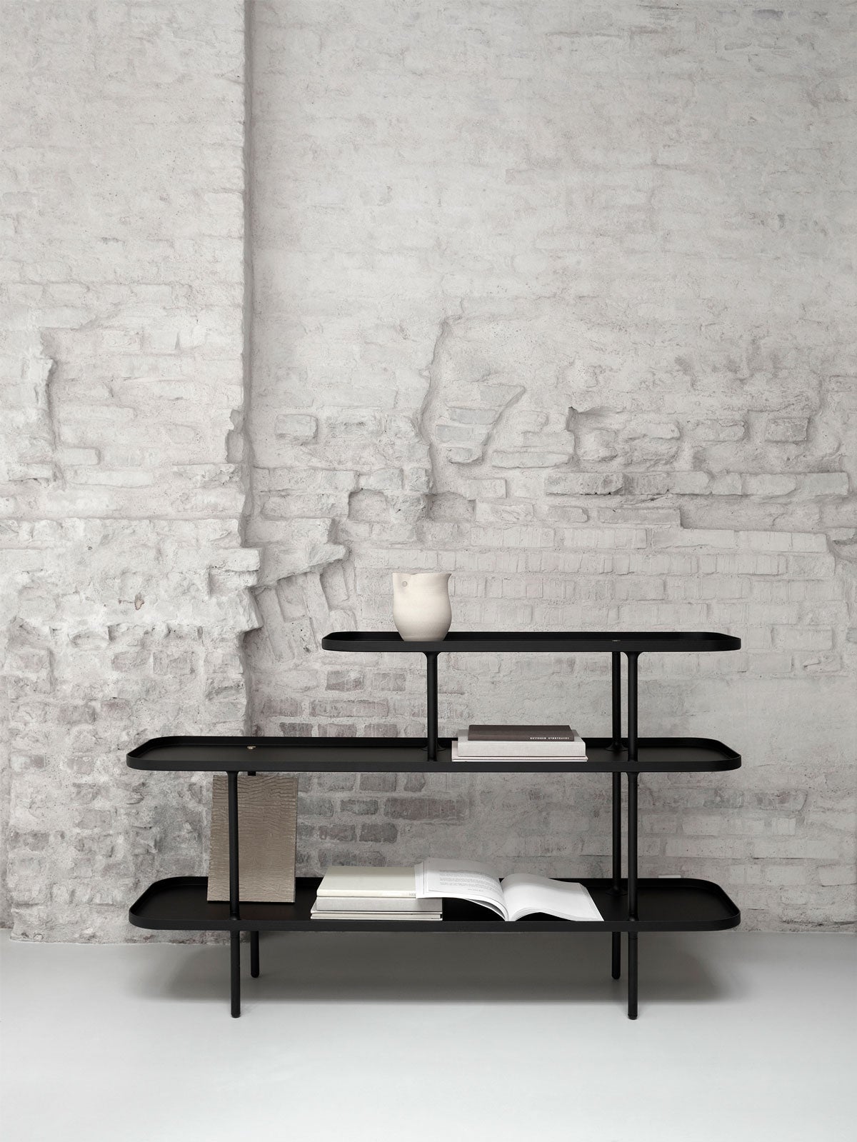 Slice Hylla Medium mot vit betongvägg med dekorativa detaljer på