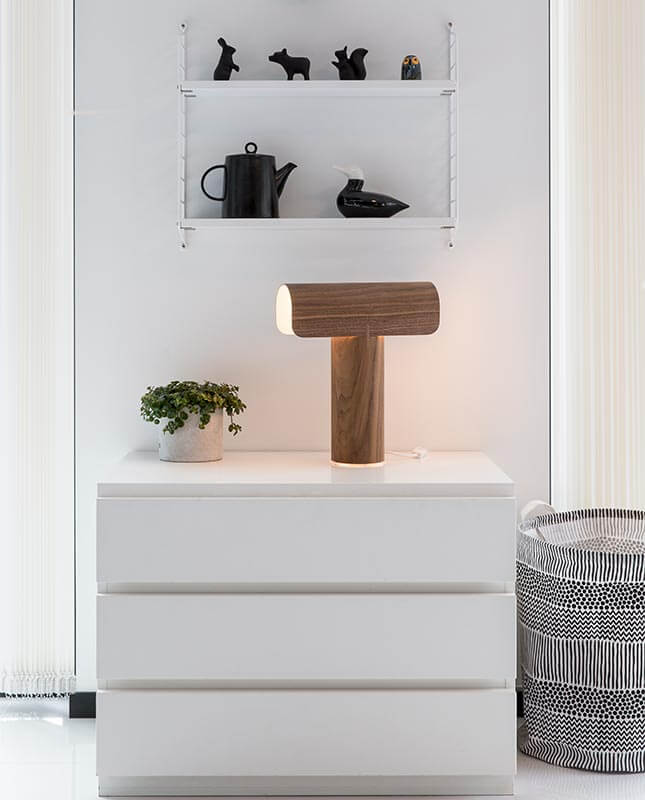 Teelo 8020 Bordslampa Valnöt på vit byrå under vägghylla med svarta prydnadsfigurer