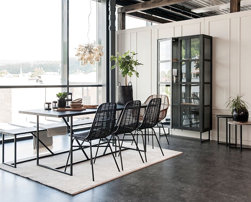 Zet Vitrinskåp i ett ljust rum med mörka matsalsmöbler