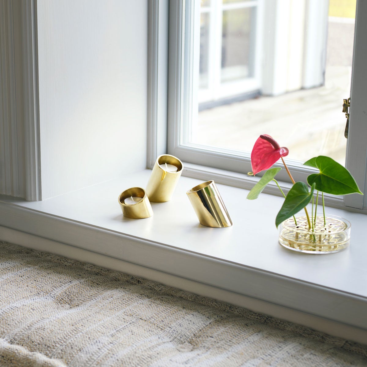 Tipp Ljushållare i mässing med värmeljus på fönsterkarm