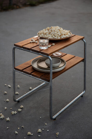 Sidobord L45 Teak med en tallrik popcorn och porslin