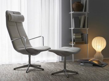 Libri Hylla i vit ask bakom en fåtölj med fotpall