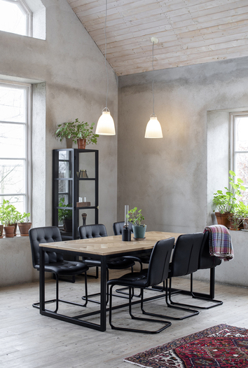 Frank Stol i svart PU vid Fishbone Matbord på matplats i industriell inredning