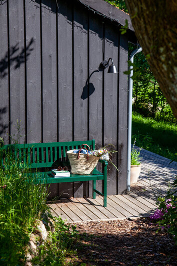 Brighton Bänk intill svart husvägg i utomhusmiljö