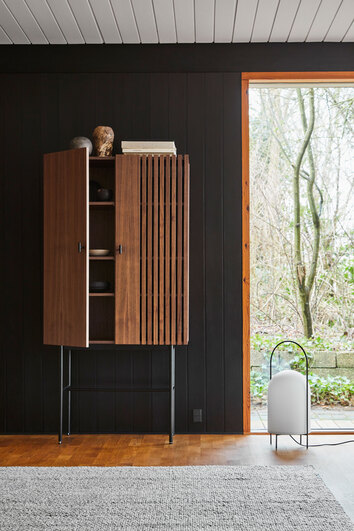 Array Highboard 80 Valnöt halvöppet med dekorativa detaljer vid fönster som vetter ut mot grönska