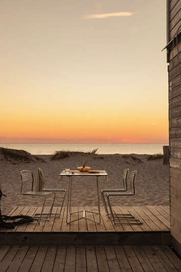 High Tech Stol Varmförzinkad runt High Tech Bord 110 i solnedgång på sandstrand