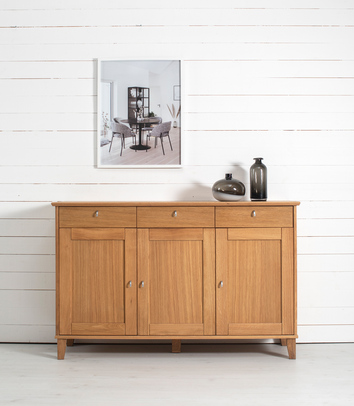 kliden Sideboard vid vit trävägg med tavla med möbelmotiv