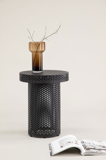 Bearsden Sidobord dekorerat med vas med kvistar bredvid ett uppslaget magasin