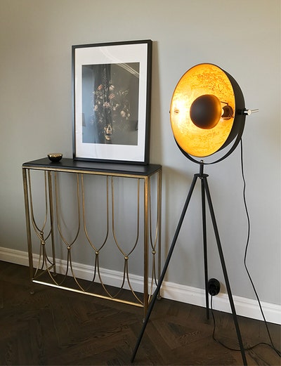 Captain-golvlampa-mini-svart-miljo.jpg Captain Mini Golvlampa Sandsvart / Guld bredvid ett avlastningsbord med en tavla