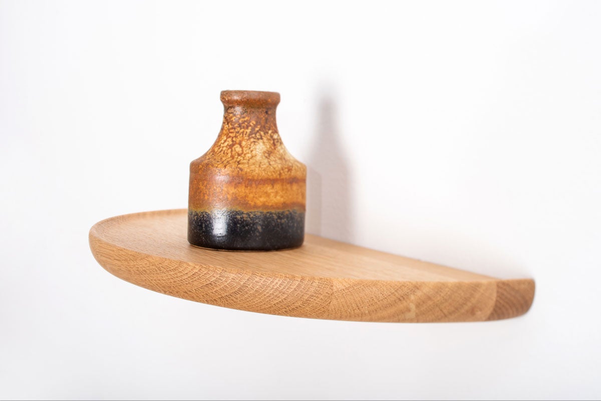 Mu Vägghylla på vit vägg med dekorativ vas i flerfärgat stengods