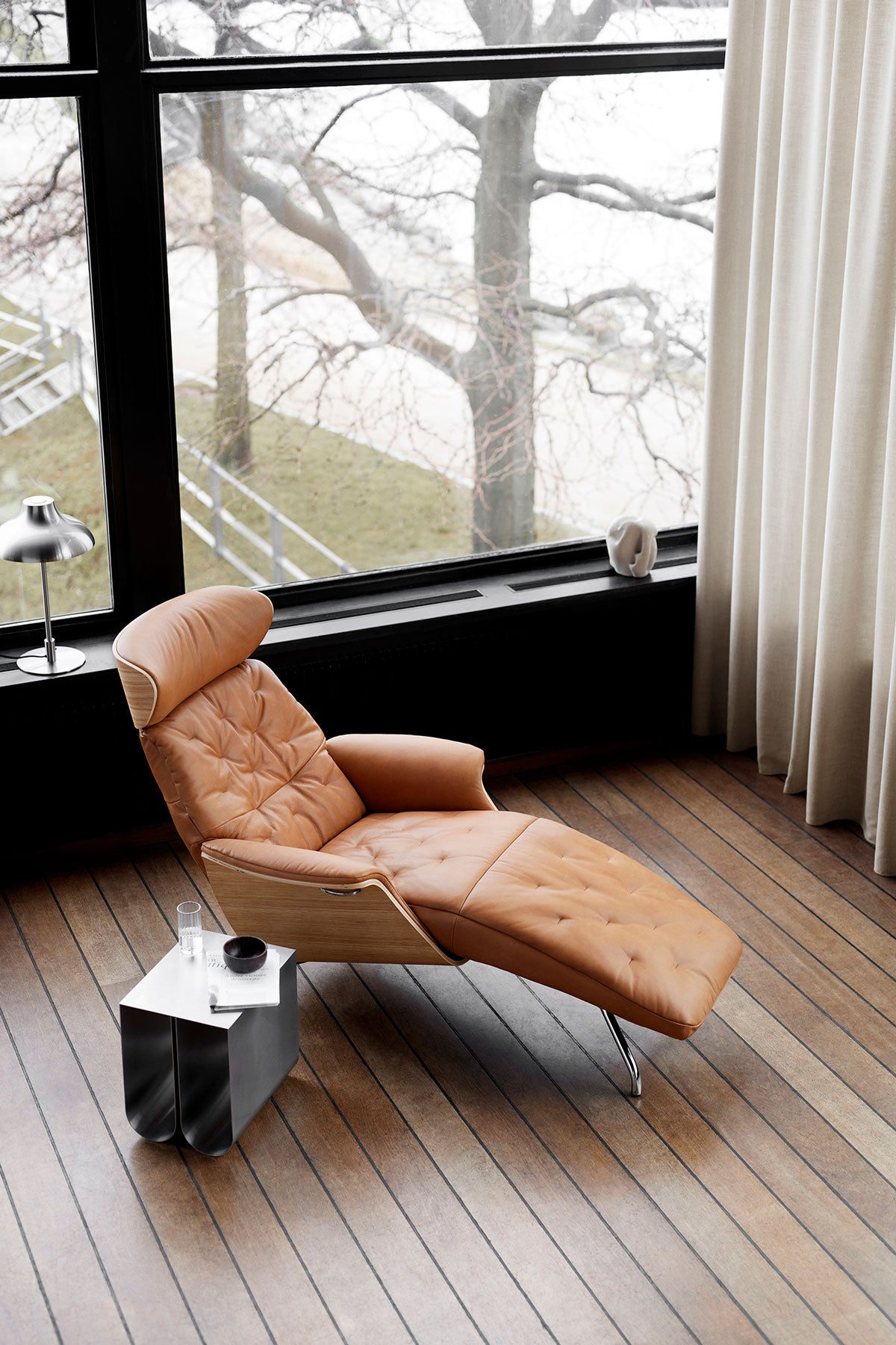 Volden Schäslong med fanérsidor i lädret Dakota Modern Cognac Brown framför fönster i vardagsrum