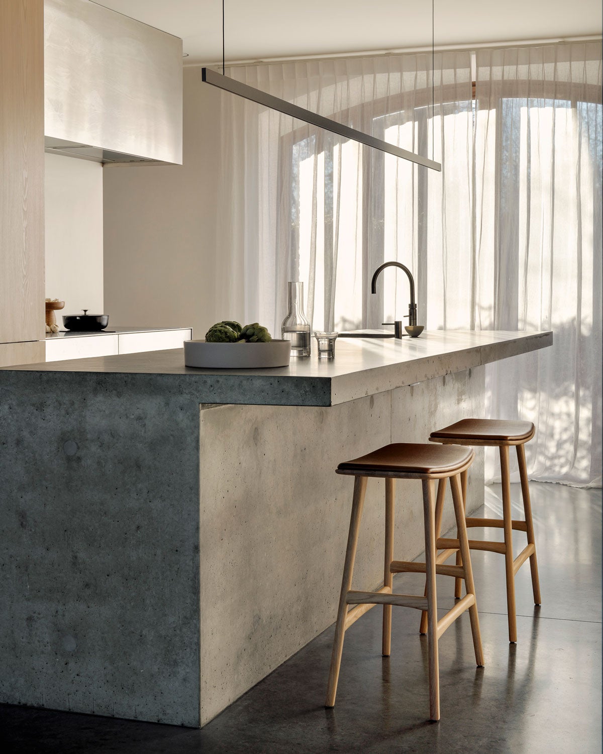 Osso Barpall Läder Cognac vid köksö i betong