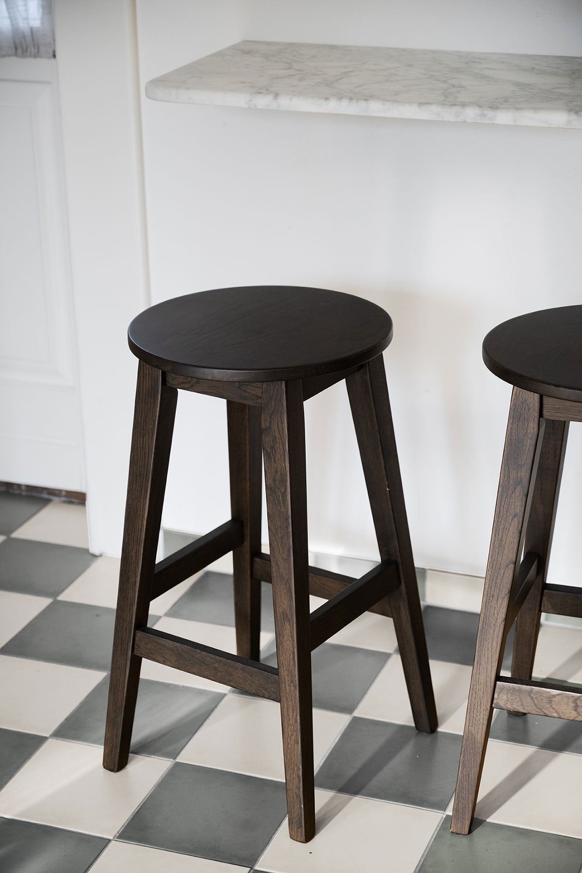 Austin barpall i brun ek på ett rutigt köksgolv