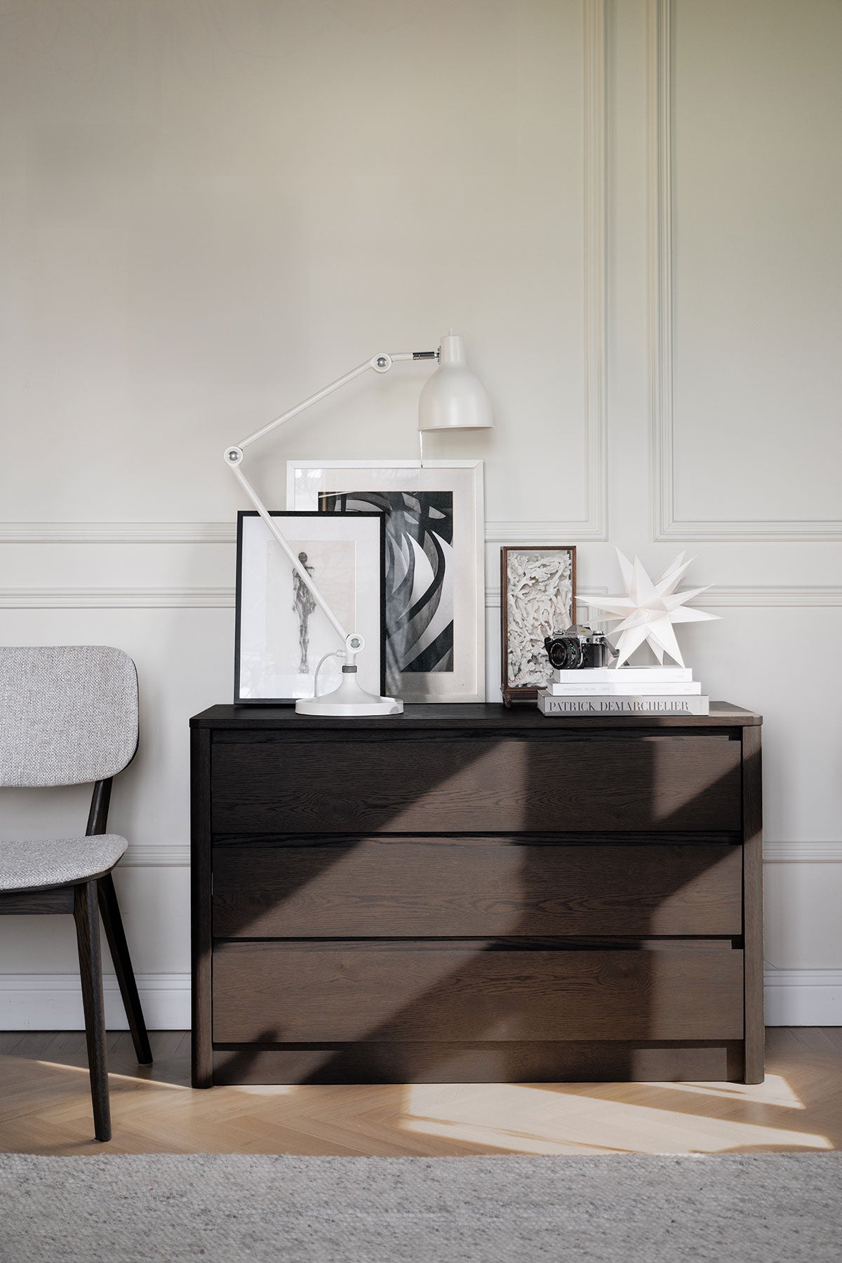 Melstone Byrå i brun ek dekorerad med en lampa, tavlor och böcker