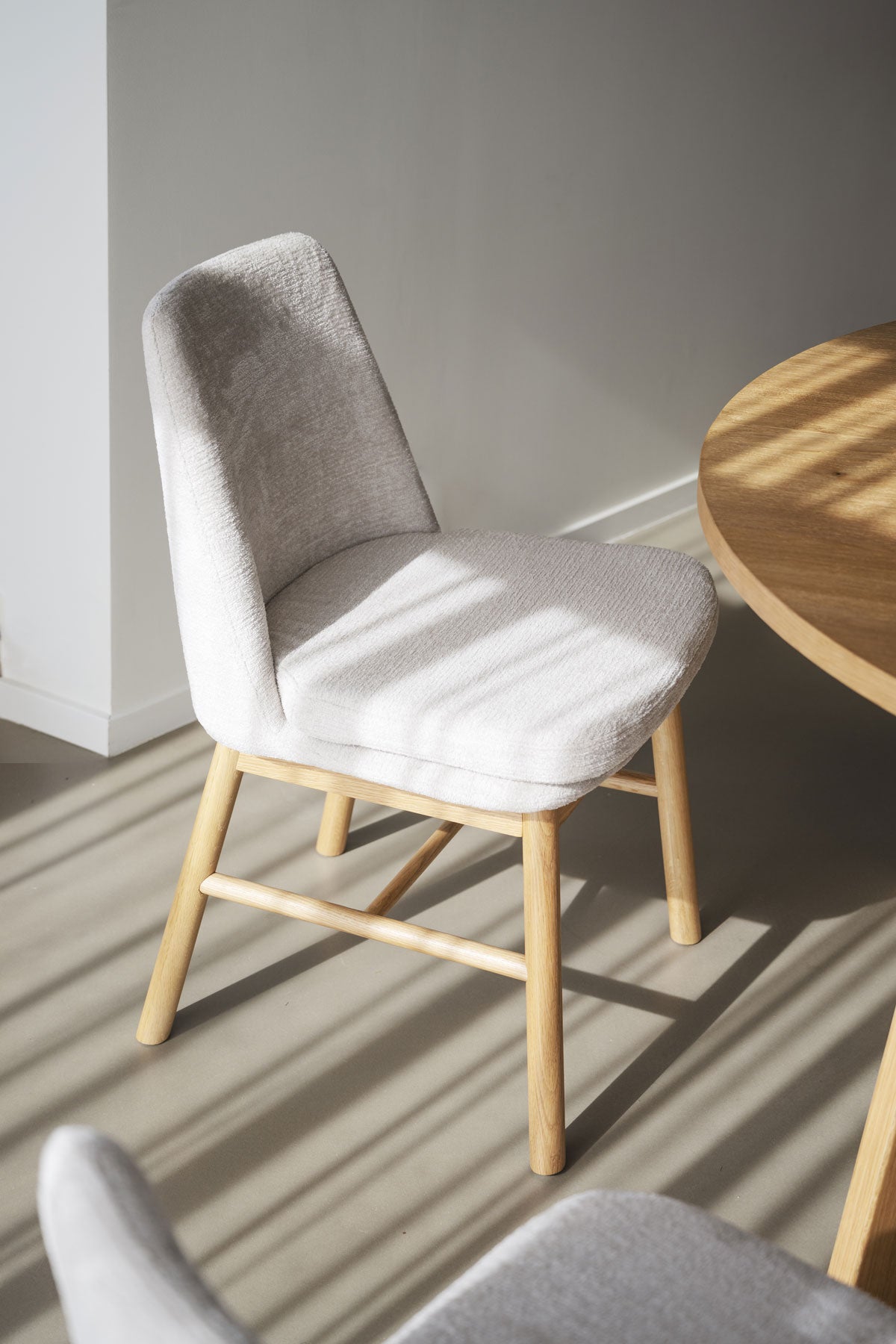 Amesbury matstol från Rowico i ljusbeige tyg och benställning i oljad ek.