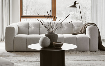 Alps soffa ståendes i ett ljust och mysigt vardagsrum med ett runt litet soffbord