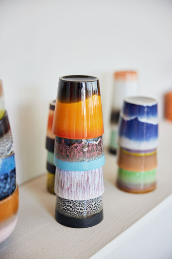 70s Ceramics Kaffe Muggar Stellar på en hylla med en blandning av massa olikfärgade koppar. 