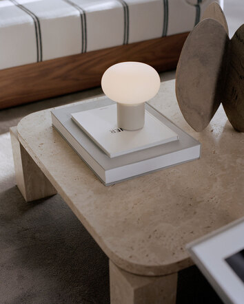 Karl Johan Portabel Bordslampa Light Grey på soffbord i marmor med dekorativa böcker